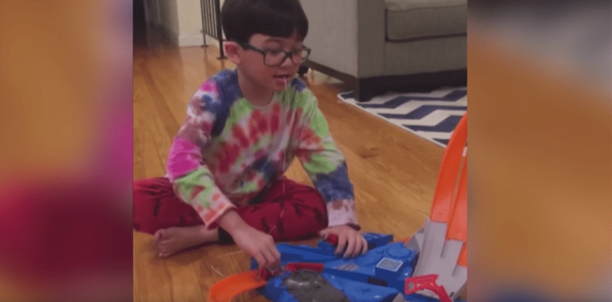 Kind lässt sich lockeren Zahn von vorbeischnellendem Auto ziehen